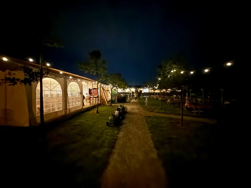 Der Biergarten bei Nacht, das Zelt leuchtet von innen.