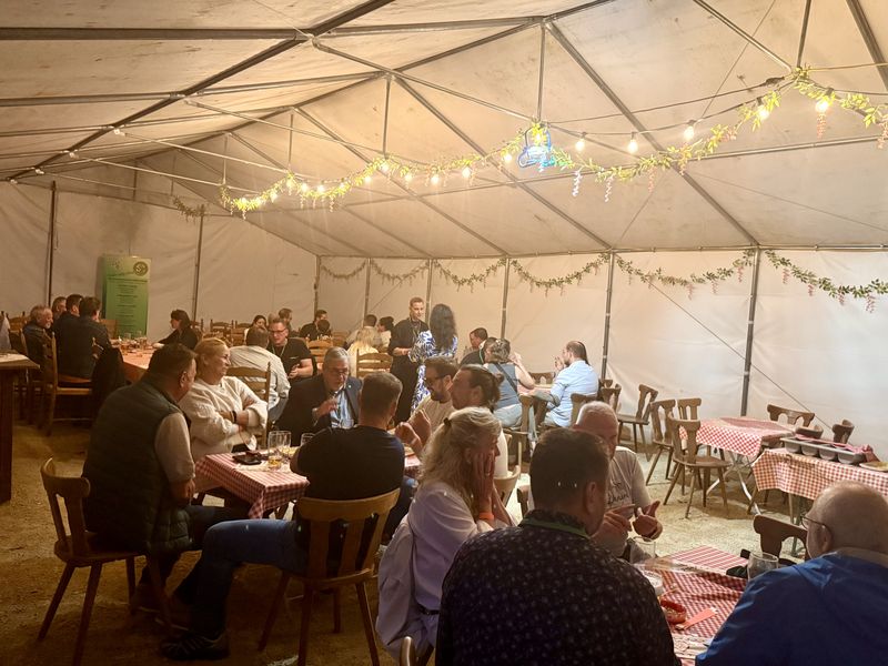 Das beleuchtete Festzelt mit vollen Tischen am Abend.